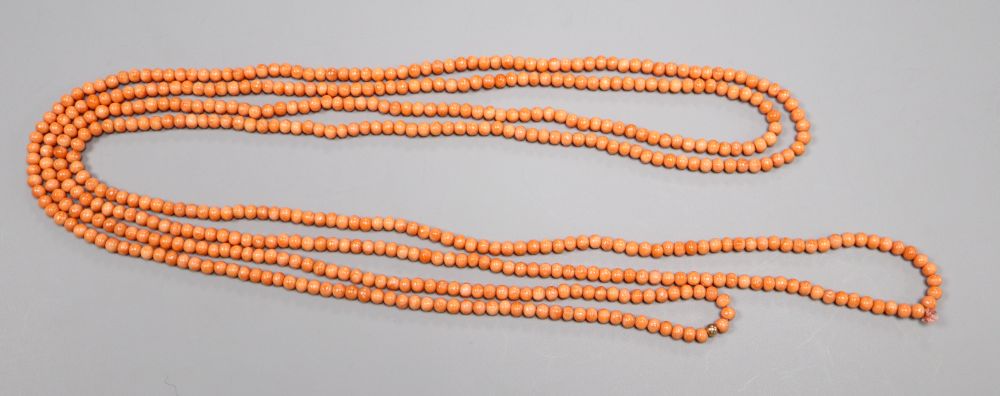 A single strand coral bead necklace, with yellow metal spacer, 197cm, gross weight 56 grams,